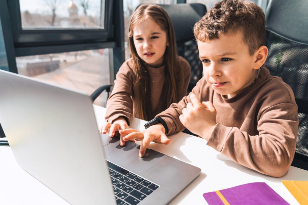 A boy and girl looking at a computer screen