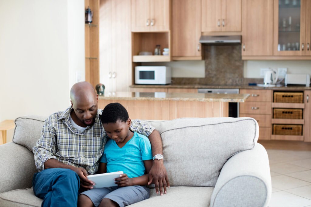 Father and son reading together, showing why homeschooling and unschooling are growing