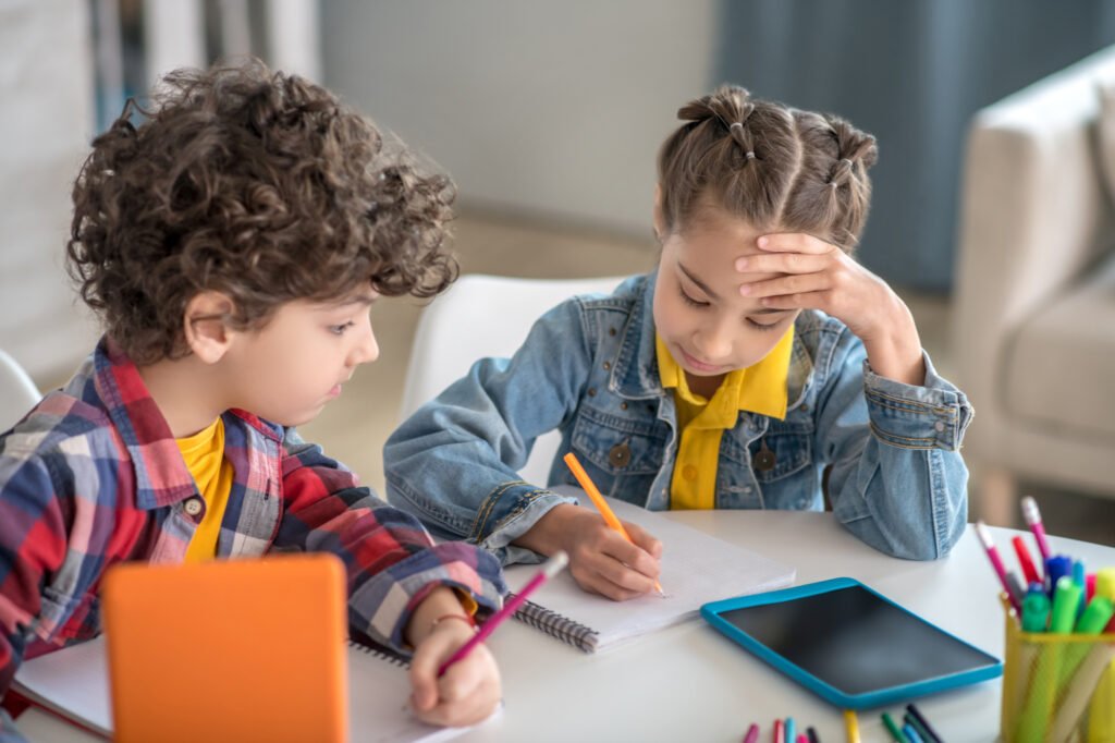 Two children completing writing exercises with Quill.org